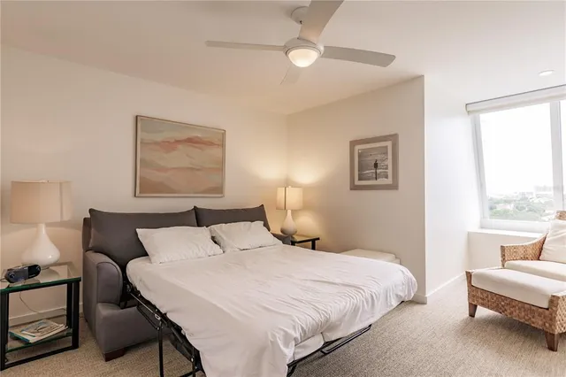 a bedroom with a bed and a large window