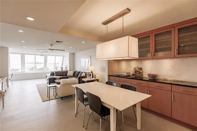 a kitchen with a stove a sink a counter top space and living room view
