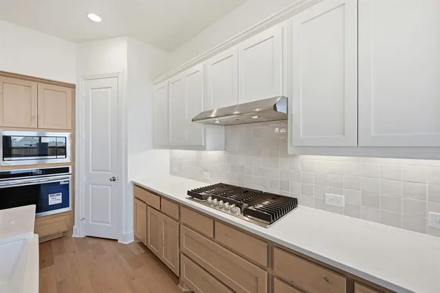 a kitchen with a stove and white cabinets