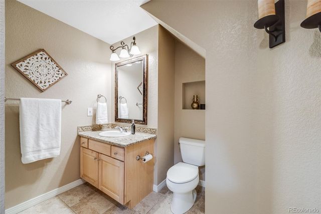 a bathroom with a granite countertop sink mirror vanity and toilet