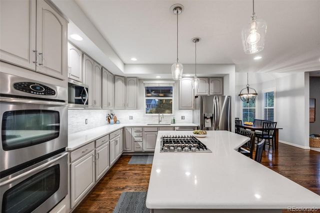 a kitchen with a sink a stove and chairs