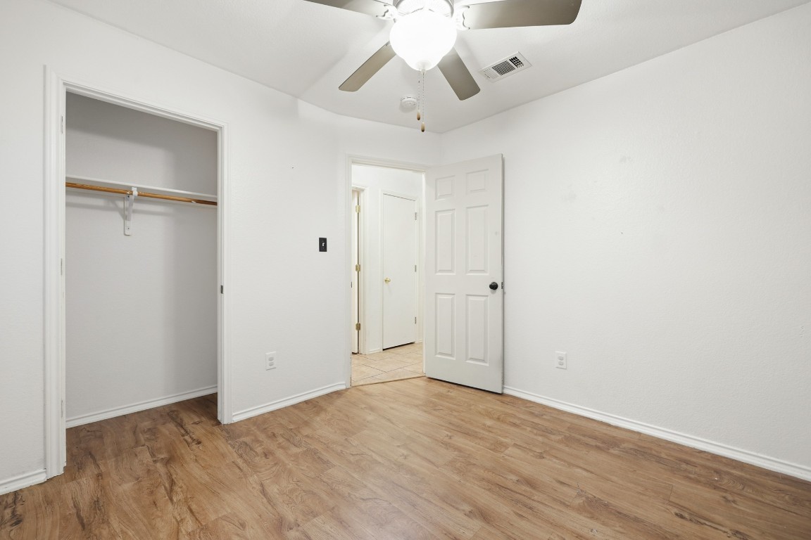 125 Blue Ridge Trail Elgin, TX 78621 - Photo 19 of 27 Unfurnished bedroom with ceiling fan, light wood-style flooring, and a closet