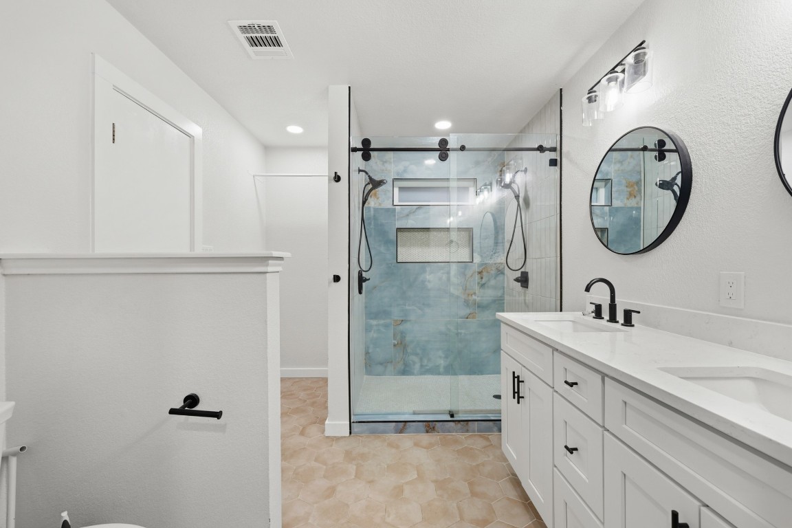 125 Blue Ridge Trail Elgin, TX 78621 - Photo 21 of 27 Bathroom featuring double vanity, a stall shower, and recessed lighting