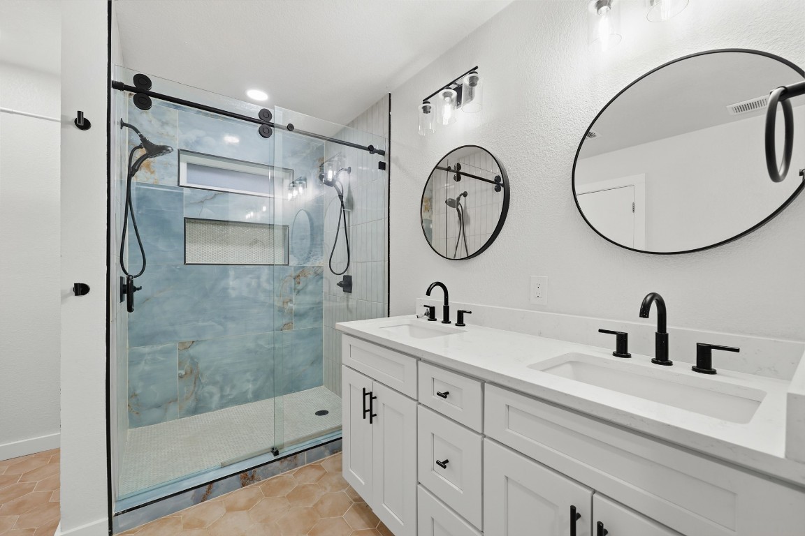 125 Blue Ridge Trail Elgin, TX 78621 - Photo 6 of 27 Updated Full bath featuring double vanity, a stall shower, and light tile patterned floors