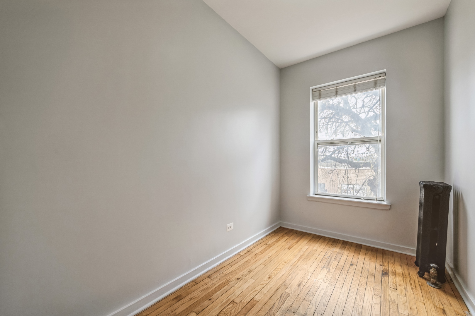 308 North Kedzie Avenue, Unit 1 Chicago, IL 60624 - Photo 3 of 11 an empty room with wooden floor and windows