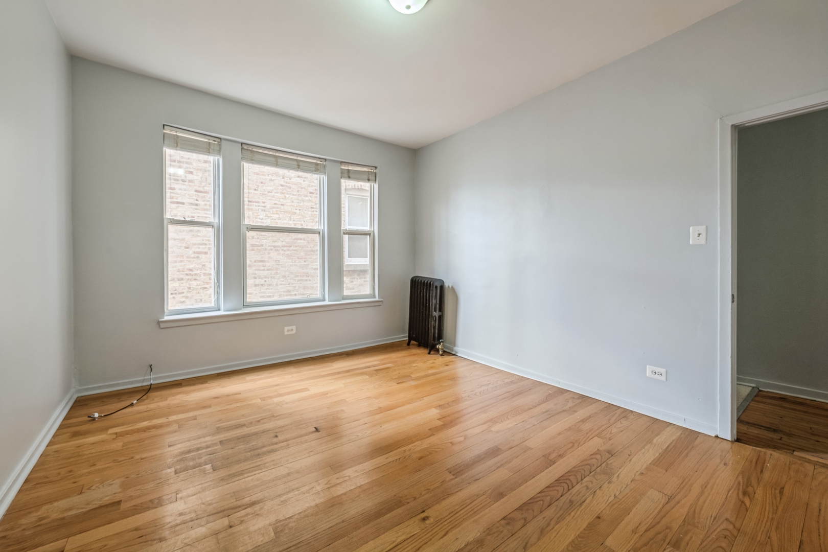 308 North Kedzie Avenue, Unit 1 Chicago, IL 60624 - Photo 7 of 11 a view of an empty room with wooden floor and a window