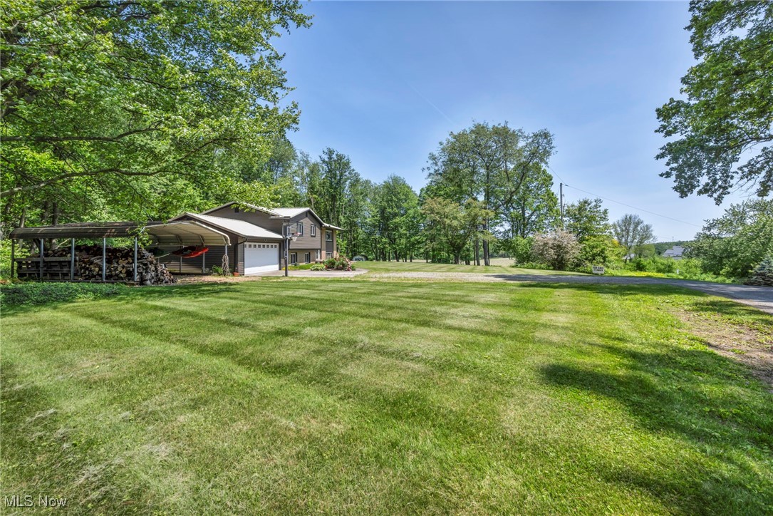 11996 Bower Road East Rochester, OH 44625 - Photo 31 of 49 View of green lawn featuring a garage