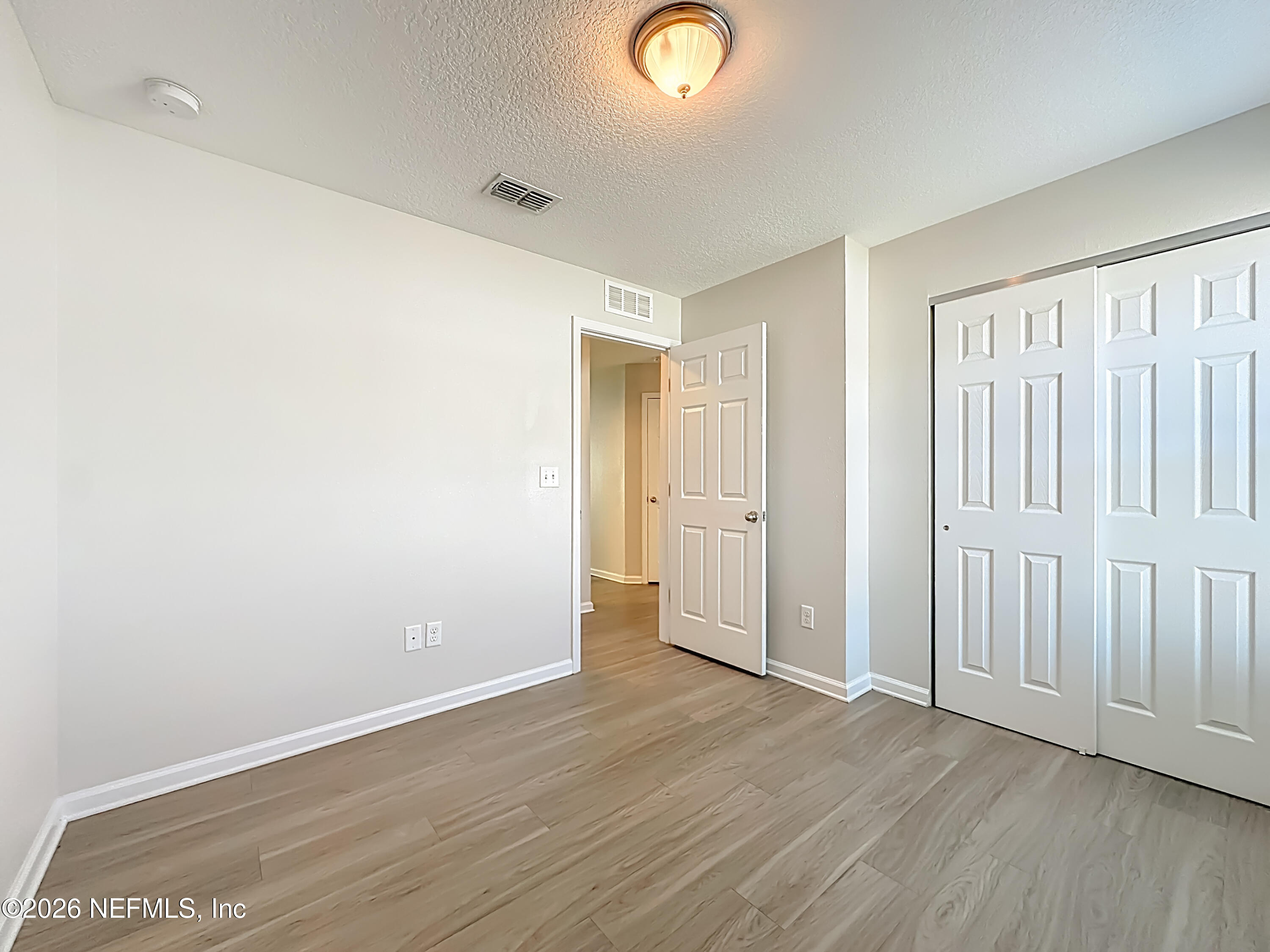 9487 Thorn Glen Road Jacksonville, FL 32208 - Photo 12 of 19 an empty room with wooden floor and closet