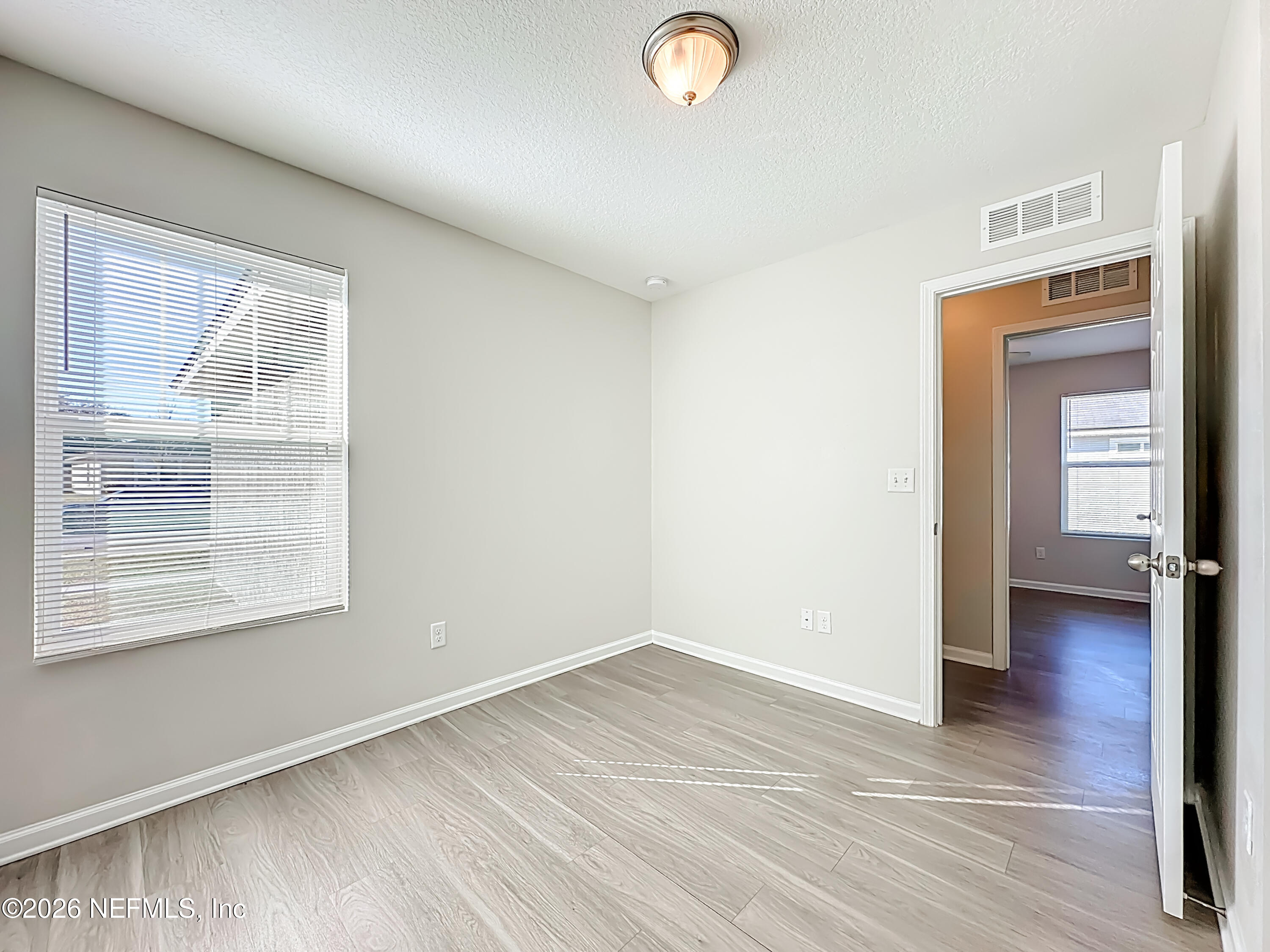 9487 Thorn Glen Road Jacksonville, FL 32208 - Photo 14 of 19 an empty room with wooden floor and windows