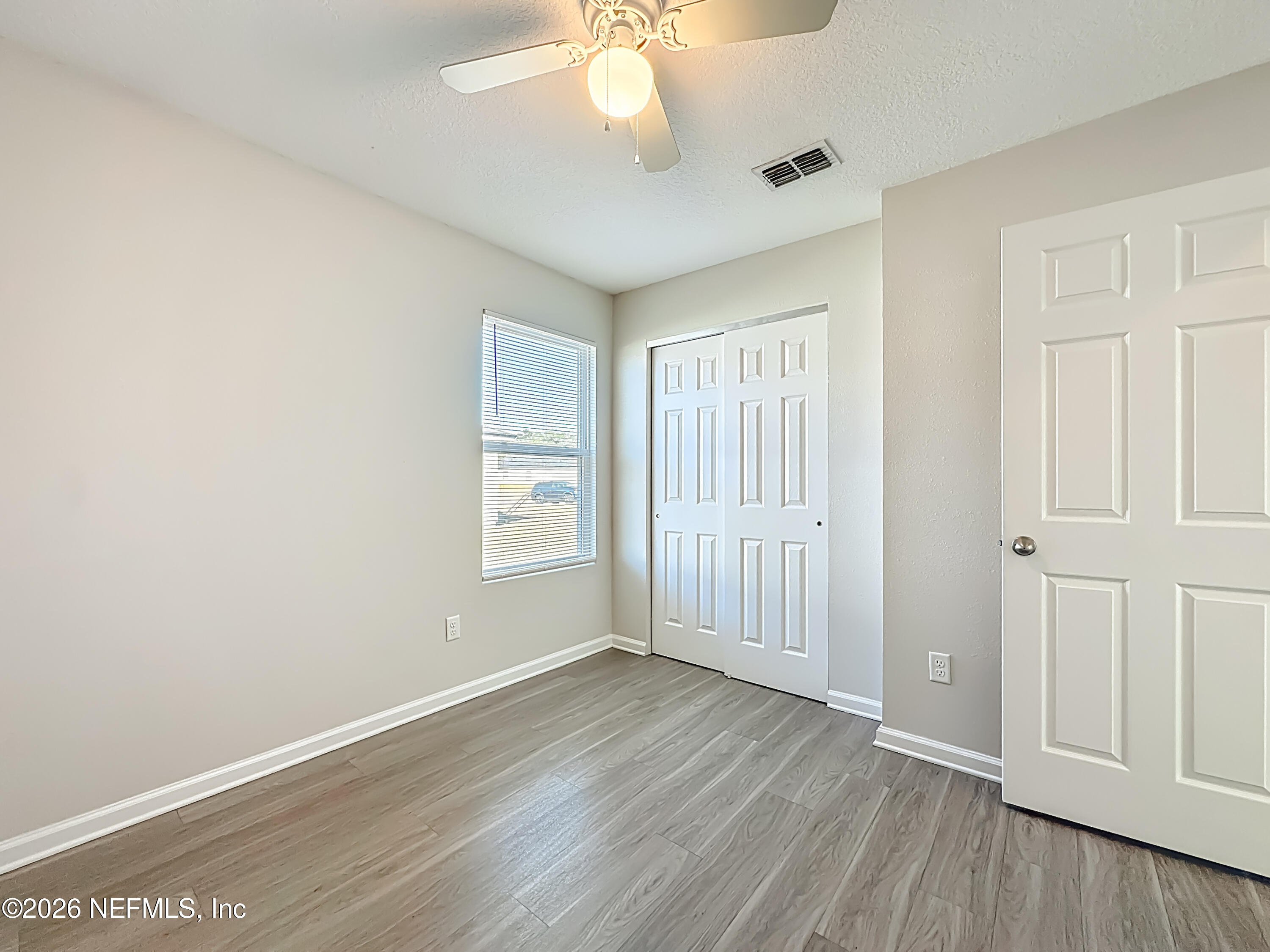 9487 Thorn Glen Road Jacksonville, FL 32208 - Photo 15 of 19 wooden floor in an empty room with a window