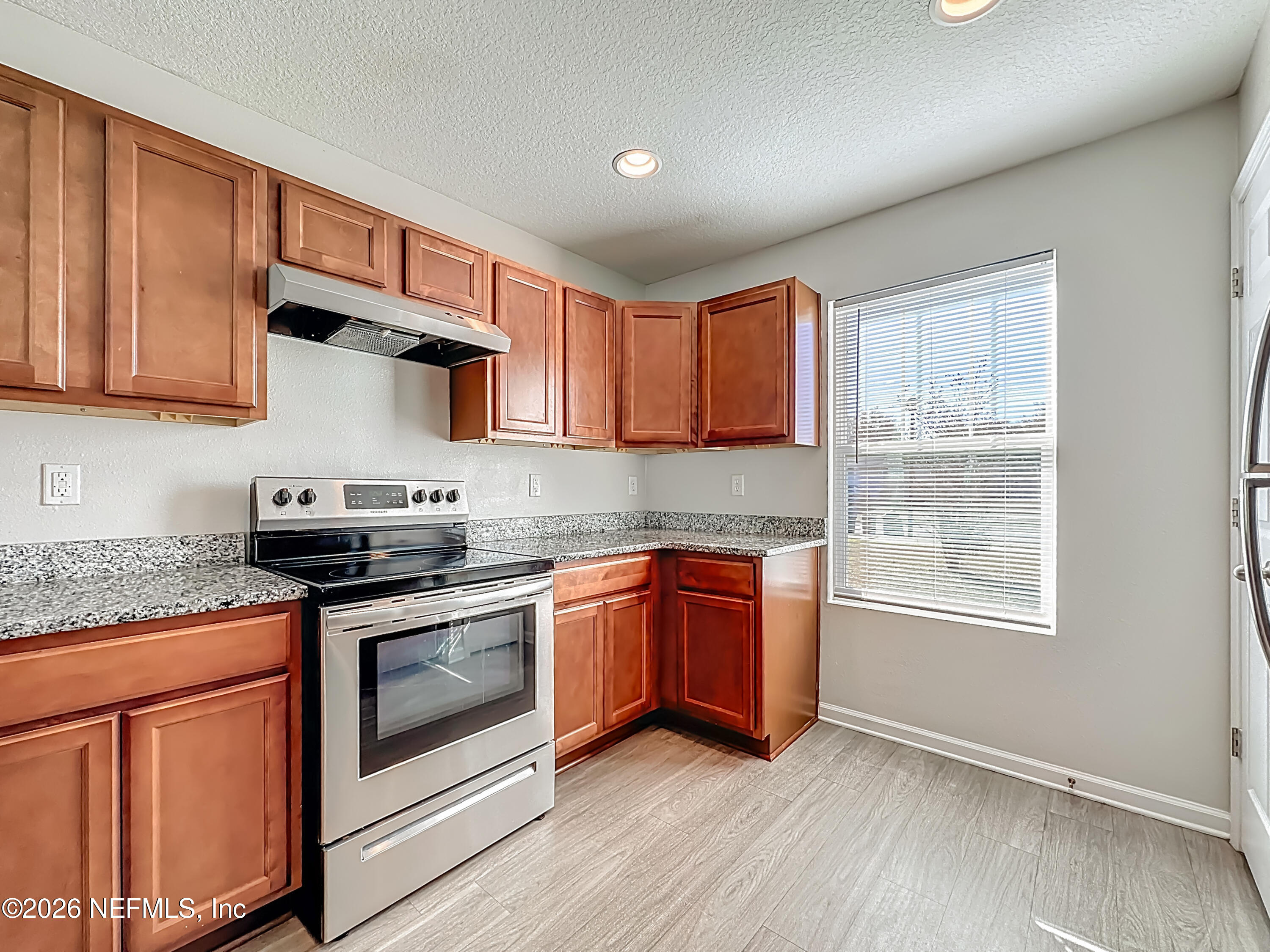 9487 Thorn Glen Road Jacksonville, FL 32208 - Photo 3 of 19 a kitchen with stainless steel appliances granite countertop a stove a sink and a microwave