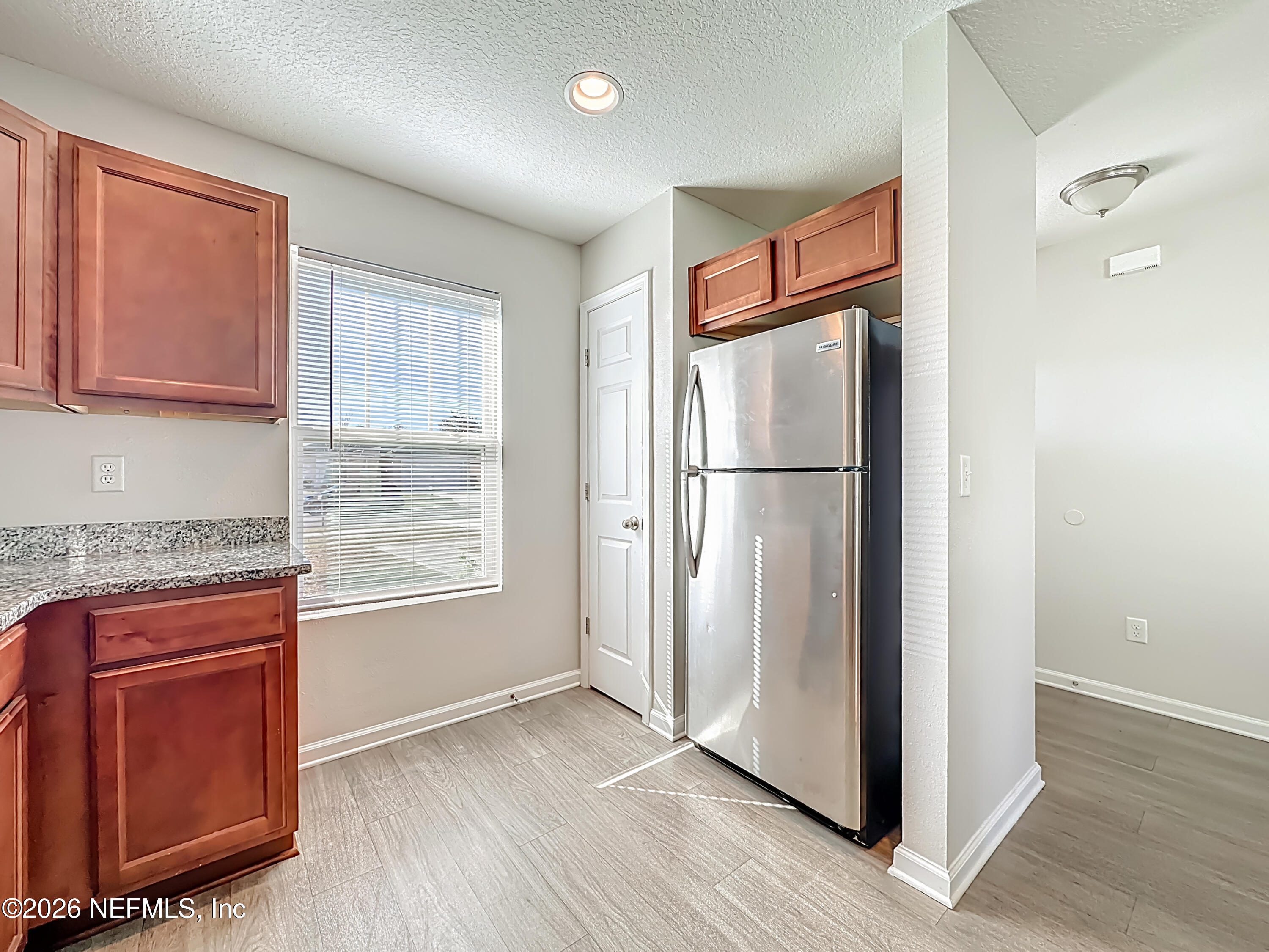 9487 Thorn Glen Road Jacksonville, FL 32208 - Photo 4 of 19 a view of a kitchen with wooden floor and refrigerator