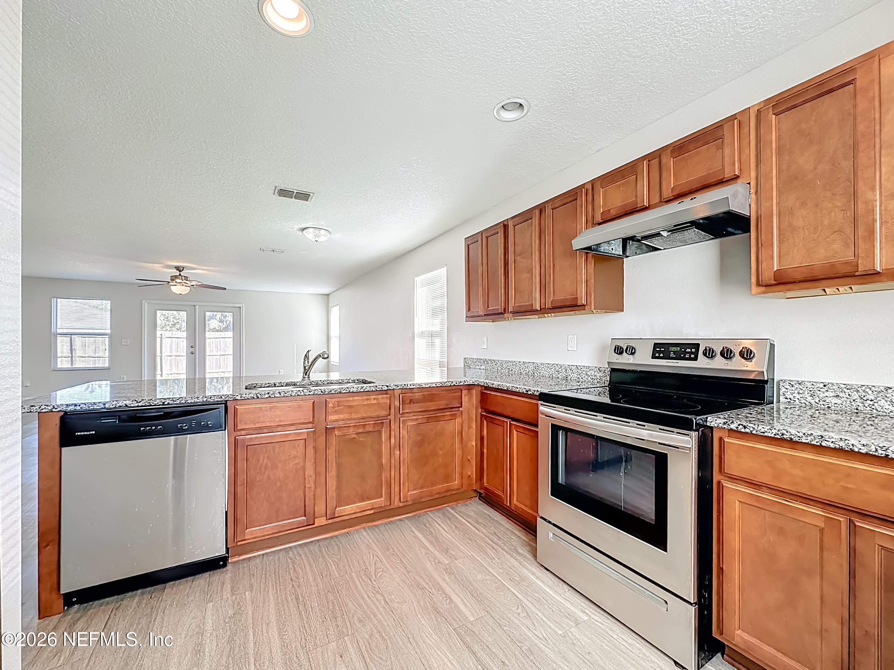 9487 Thorn Glen Road Jacksonville, FL 32208 - Photo 5 of 19 a kitchen with stainless steel appliances granite countertop wooden floor sink stove and granite counter top