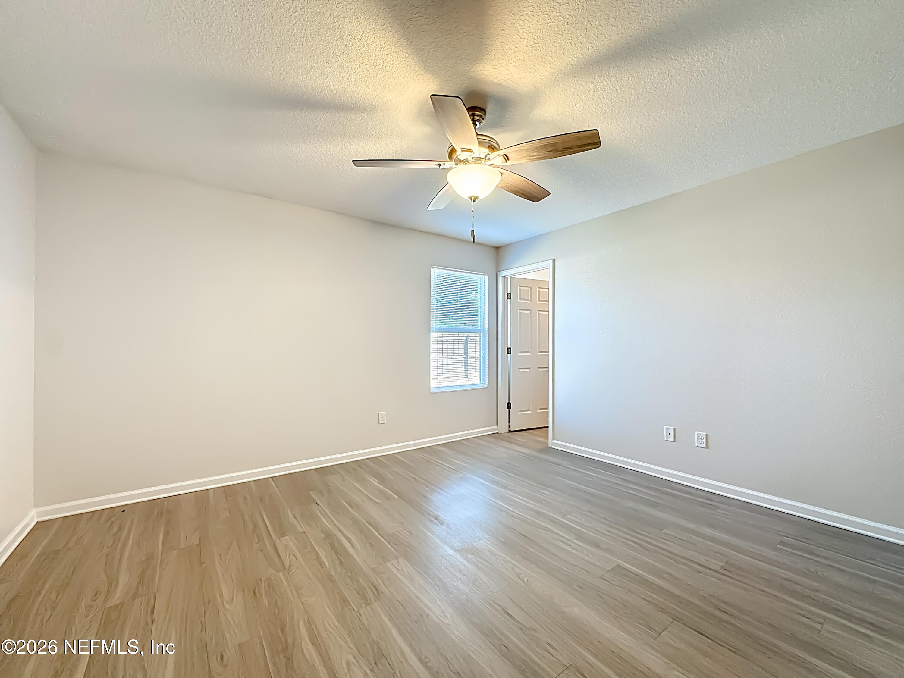 9487 Thorn Glen Road Jacksonville, FL 32208 - Photo 9 of 19 an empty room with wooden floor and a ceiling fan