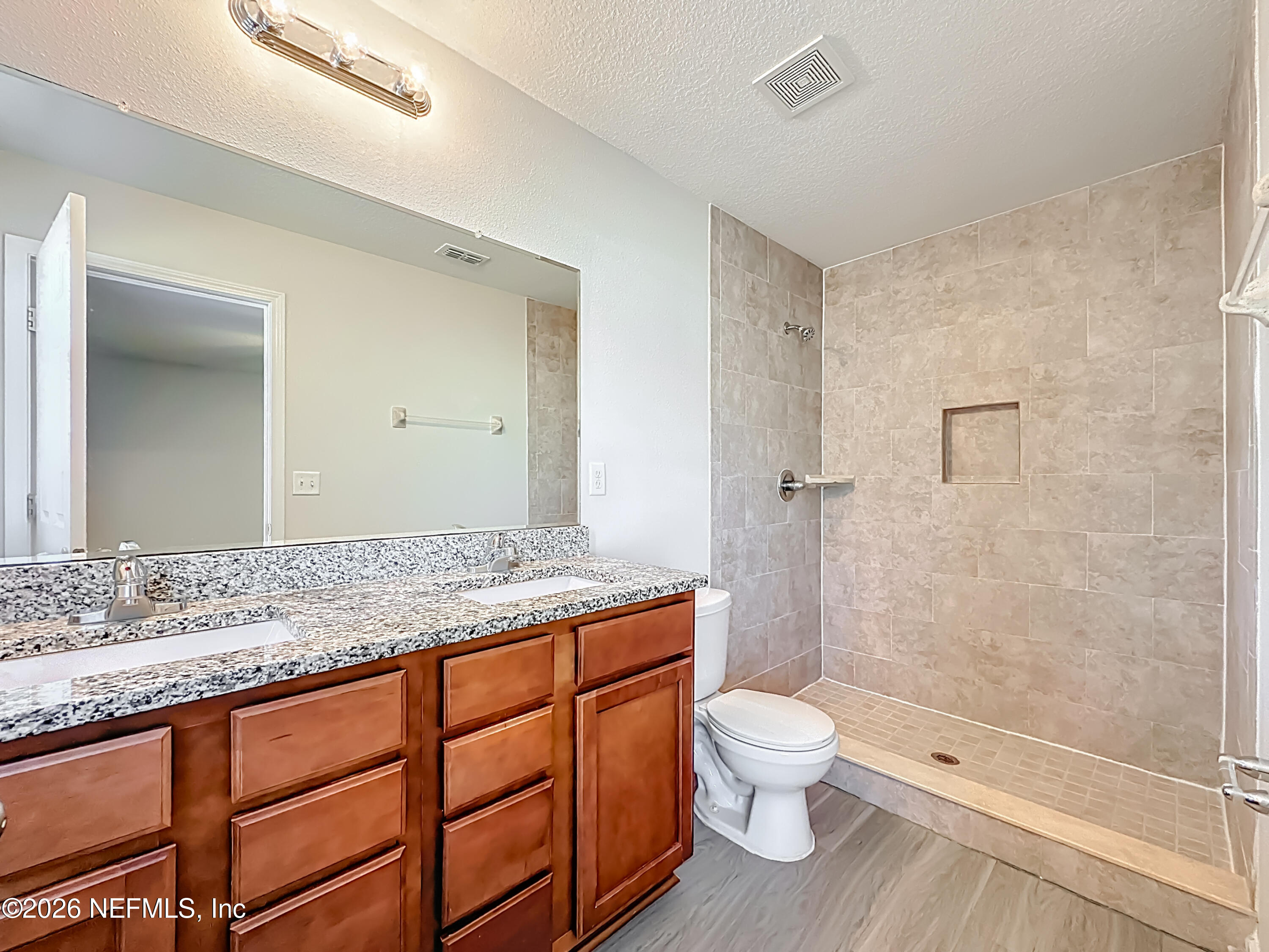 9487 Thorn Glen Road Jacksonville, FL 32208 - Photo 10 of 19 a bathroom with a granite countertop toilet a sink and a shower
