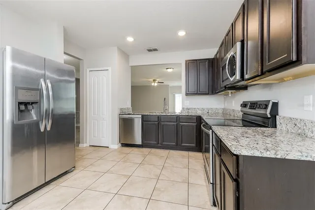 a kitchen with stainless steel appliances granite countertop a refrigerator and a sink