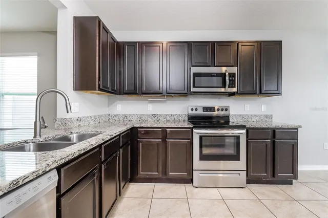 a kitchen with granite countertop a sink and stainless steel appliances