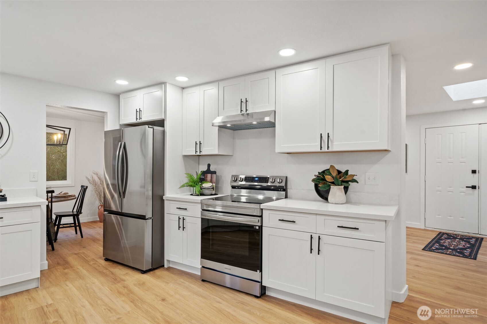 13080 Old Military Road Northeast Poulsbo, WA 98370 - Photo 11 of 29 a kitchen with stainless steel appliances white cabinets and wooden floors