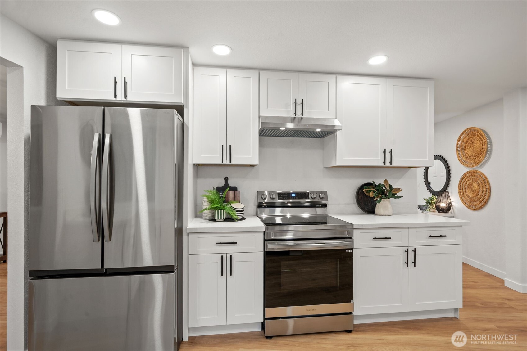 13080 Old Military Road Northeast Poulsbo, WA 98370 - Photo 12 of 29 a kitchen with stainless steel appliances granite countertop a refrigerator stove a sink and white cabinets with wooden floors