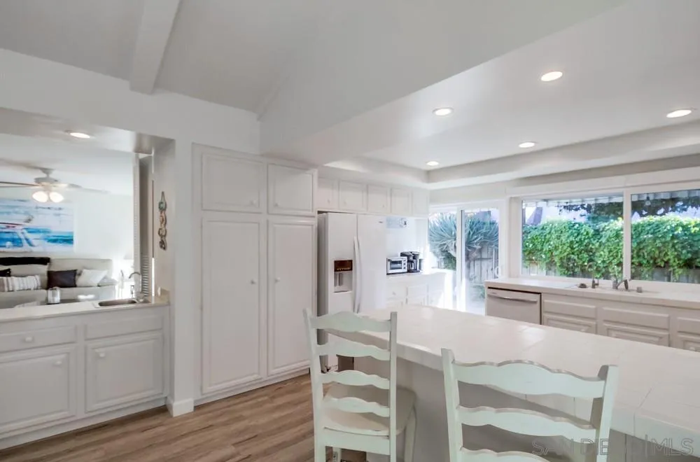 10 GingerTree Lane Coronado, CA 92118 - Photo 23 of 68 a kitchen with white cabinets and wooden floor