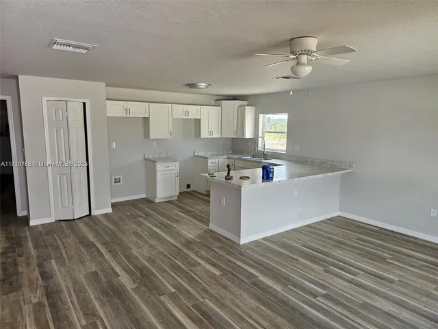 a kitchen with stainless steel appliances wooden floors and white walls
