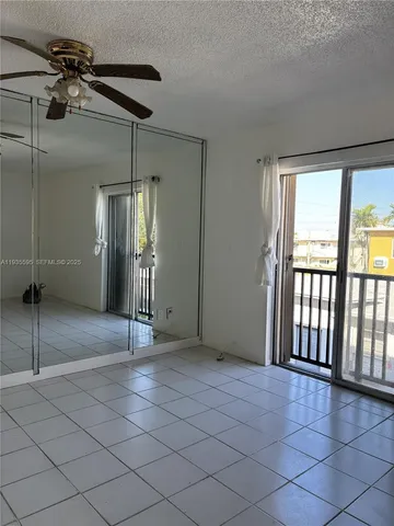 an empty room with windows and fan