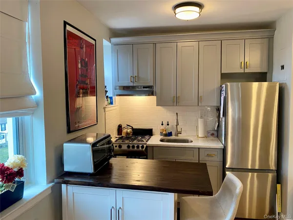 a kitchen with stainless steel appliances granite countertop a refrigerator a sink a stove counter space and cabinets