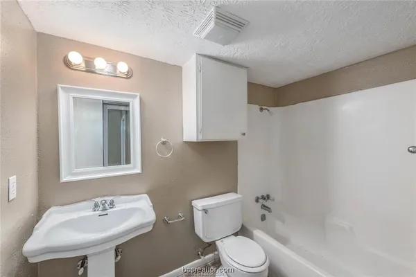 a white toilet sitting next to a bathroom sink