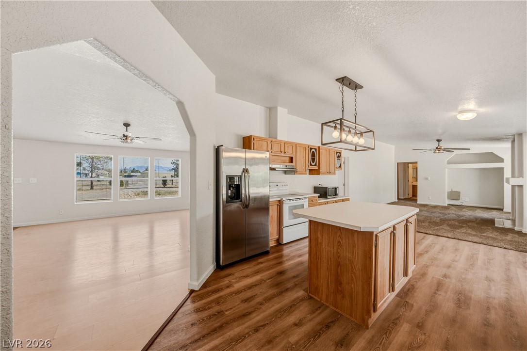 1890 West Dyer Road Pahrump, NV 89048 - Photo 5 of 40 This kitchen features wood cabinetry and a functional island, flowing into a bright living space.