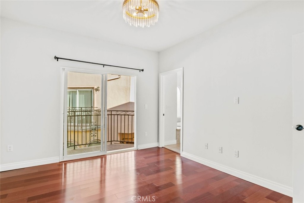 6939 Greeley Street, Unit 102 Tujunga, CA 91042 - Photo 13 of 19 a view of an empty room with wooden floor and a window