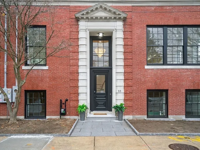 a front view of a brick house with a large windows