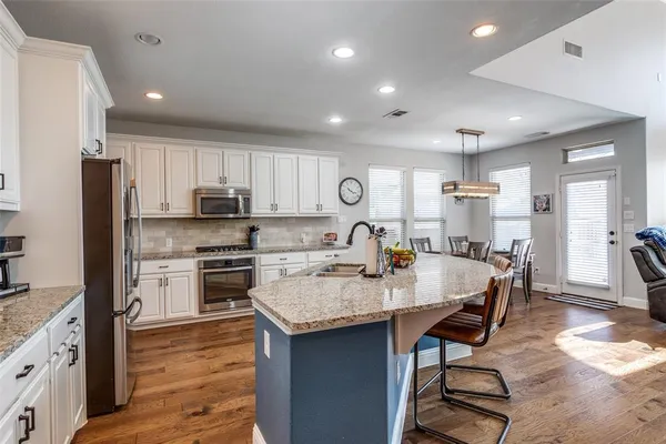 a large kitchen with kitchen island a sink table and chairs