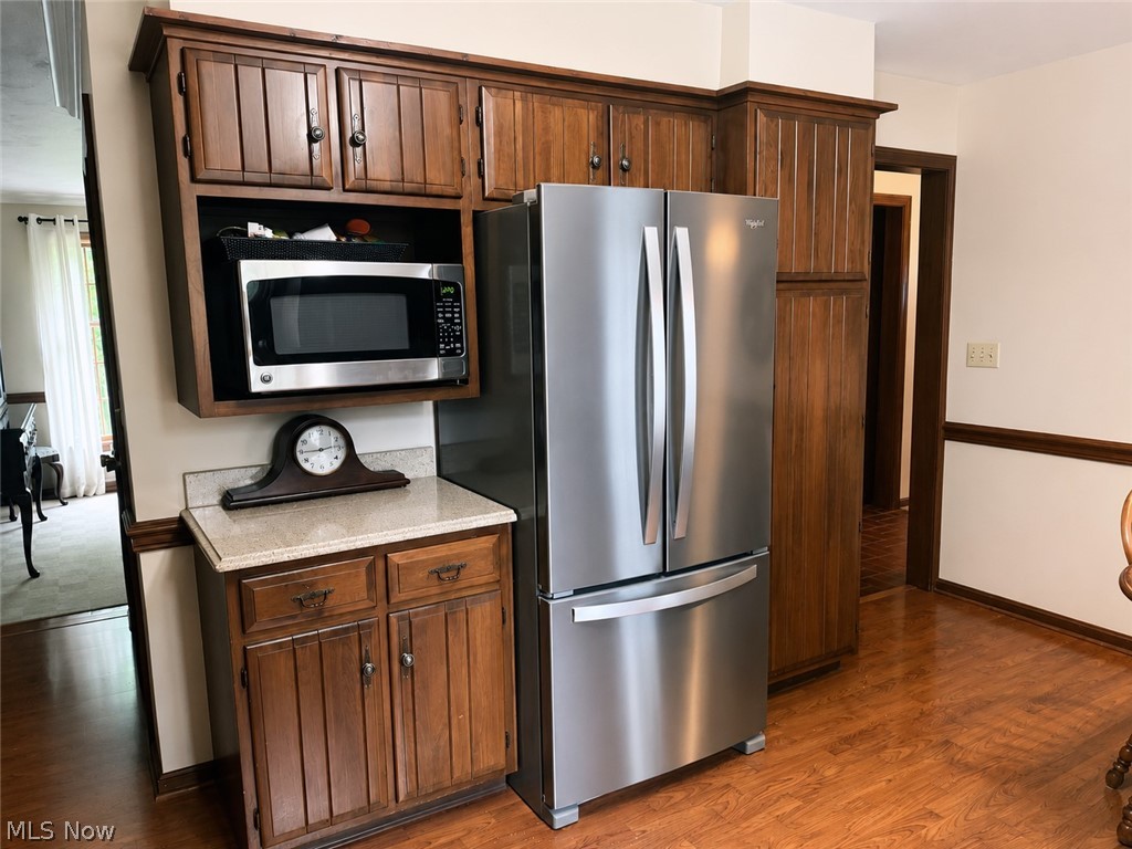 6155 Gibson Road Canfield, OH 44406 - Photo 22 of 43 Kitchen featuring wood cabinetry, a built-in microwave, stainless steel refrigerator, and wood-finish flooring
