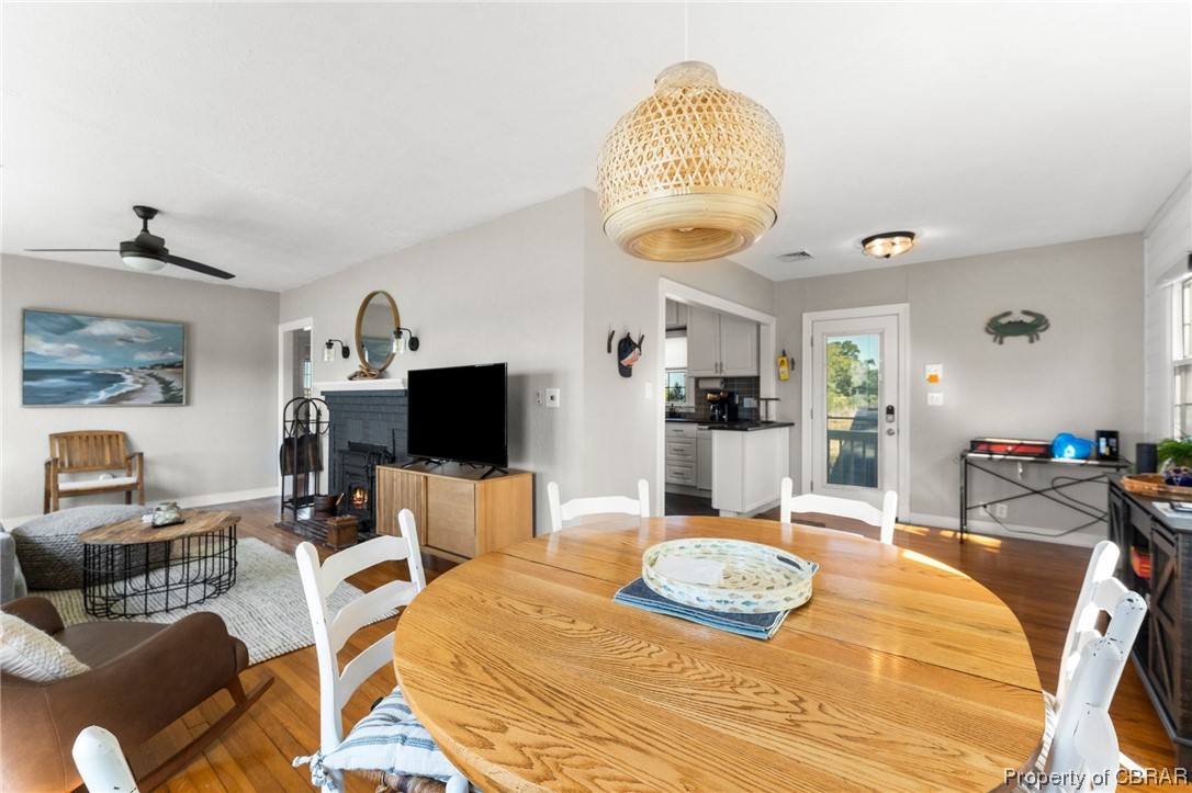 2218 Mill Creek Road Wake, VA 23176 - Photo 26 of 41 Dining room with hardwood flooring, a brick fireplace, and ceiling fan