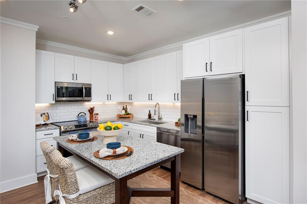 1545 Whitemarsh Road, Unit B1 Kennesaw, GA 30152 - Photo 35 of 46 a kitchen with stainless steel appliances granite countertop a dining table and chairs