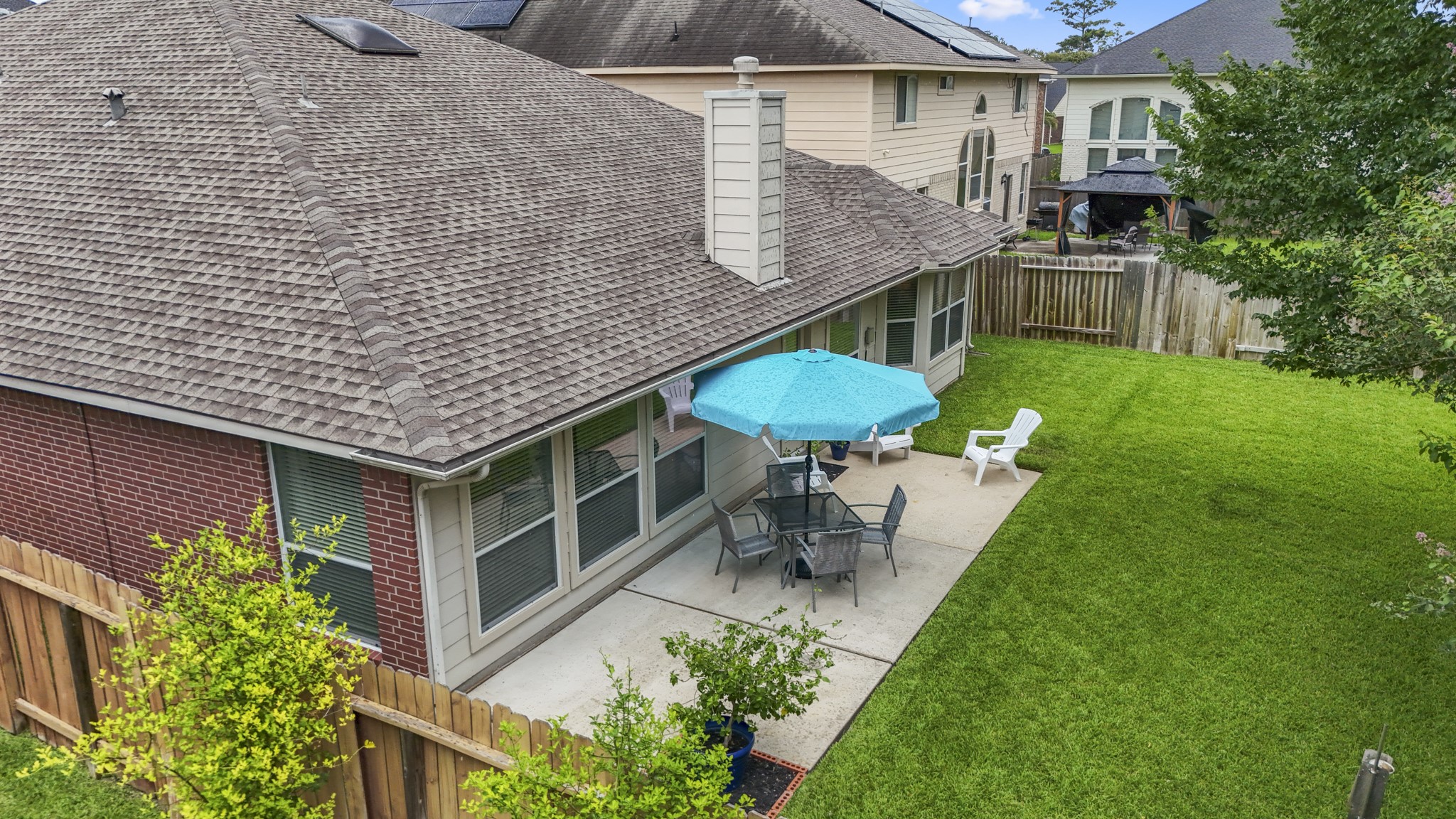 3411 Utah Beach Court Spring, TX 77388 - Photo 41 of 50 This patio view shows how easily the backyard can be enjoyed right off the main living spaces, with room for a table, umbrella, and casual outdoor seating. The door connects back inside near the breakfast room and family room, while the fenced lawn stretches alongside the patio for a simple, usable backyard setup.