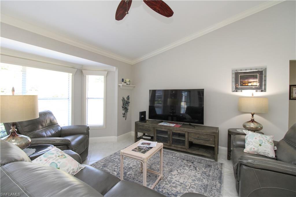 333 Wentworth Court Naples, FL 34104 - Photo 15 of 48 Tiled living room featuring vaulted ceiling, ornamental molding, baseboards, and ceiling fan