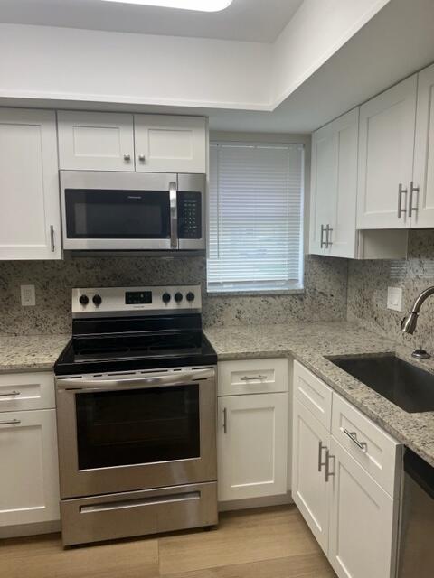 500 Northwest 53rd Street Boca Raton, FL 33487 - Photo 3 of 13 a kitchen with cabinets stainless steel appliances and a sink