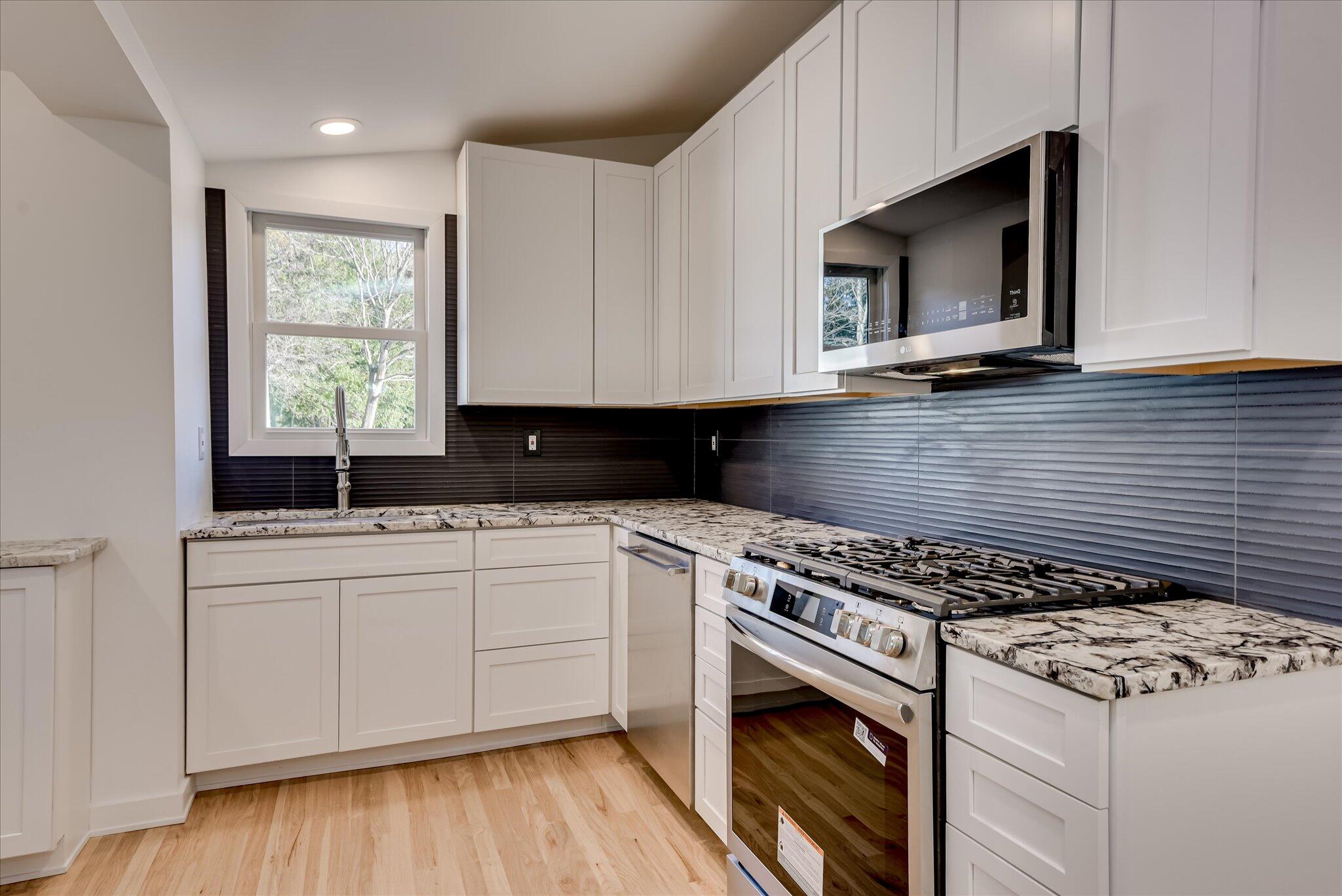 126 Mosley Road Aiken, SC 29801 - Photo 10 of 29 a kitchen with stainless steel appliances granite countertop a sink a stove a microwave oven and cabinets