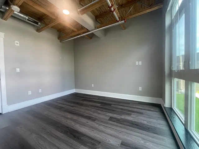 a view of a room with wooden floor and window