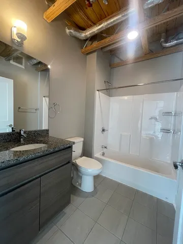 a bathroom with a granite countertop sink toilet and shower
