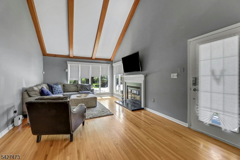 100 Easedale Road, Unit 100 Wayne, NJ 07470 - Photo 9 of 43 a living room with furniture a fireplace and a flat screen tv