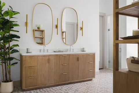 a bathroom with sinks a mirror and a potted plant