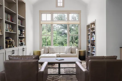 a living room with furniture a bookshelf and a window