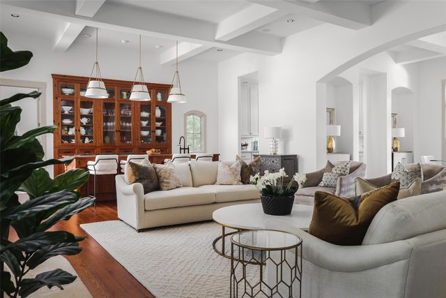 a living room with furniture a chandelier and a dining table