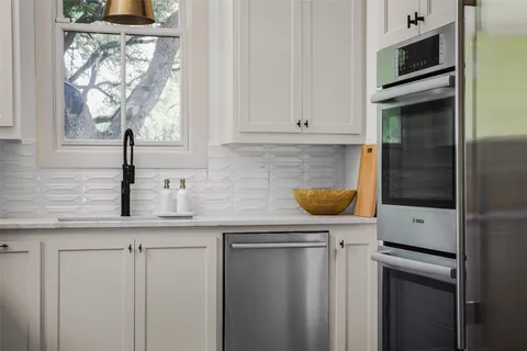 a kitchen with stainless steel appliances granite countertop a sink and a microwave