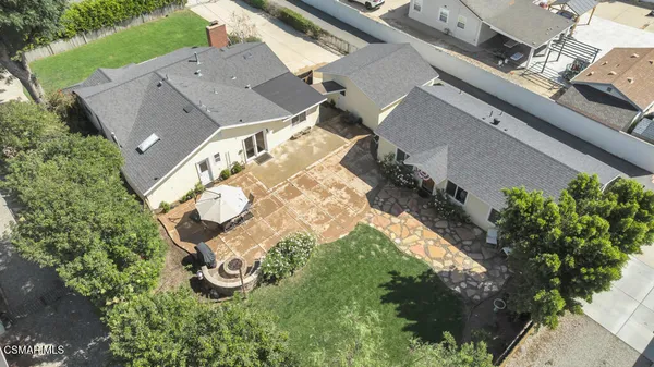 a kitchen with stainless steel appliances a dining table chairs refrigerator and microwave