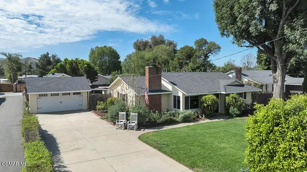 a view of a house with backyard and a tree