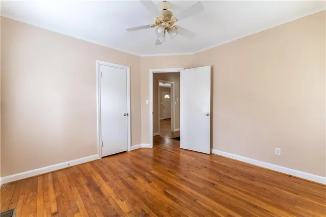a view of a room with wooden floor and a ceiling fan