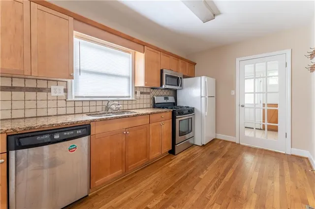 a kitchen with wooden floors and white appliances